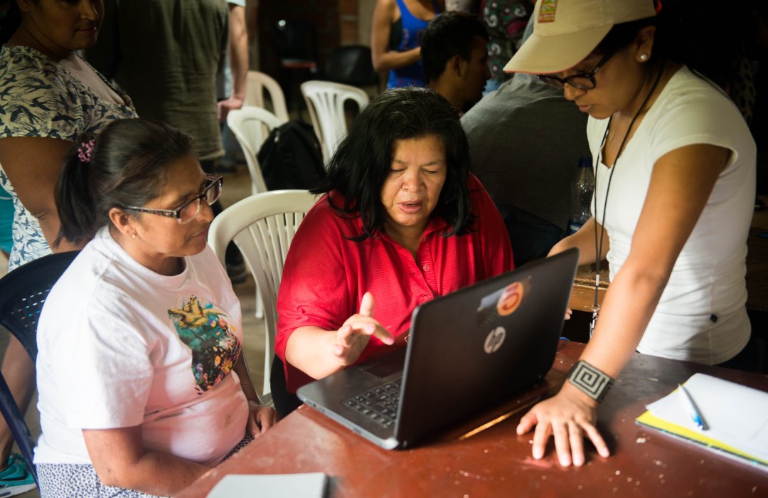 El Proyecto CPSP en Altos de Oriente incluyó realizar una Feria de Salud para tratar los problemas identificados por la comunidad como prioritarios. La Feria incluyó un curso de capacitación en primeros auxilios, una clínica de desparasitación, un taller sobre cómo acceder a información de salud en línea y un censo. En la fotografía, la embajadora estudiantil Liliana Taramuel les enseña a los líderes comunitarios cómo usar la computadora y acceder a internet a través de un pequeño café internet ubicado dentro del centro comunitario. En los próximos meses, asimismo se harán disponibles a la comunidad servicios de telemedicina, a los cuales podrá accederse desde el café internet.